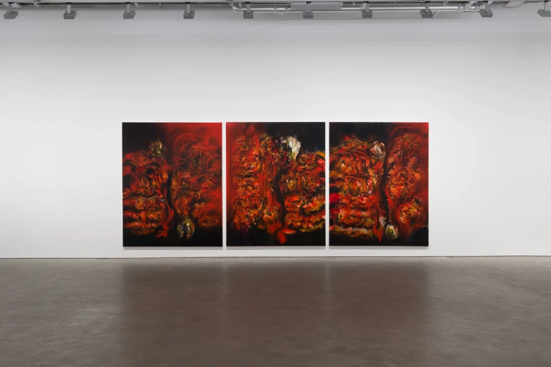 Three large red-and-black paintings displayed as a triptych on a white gallery wall.